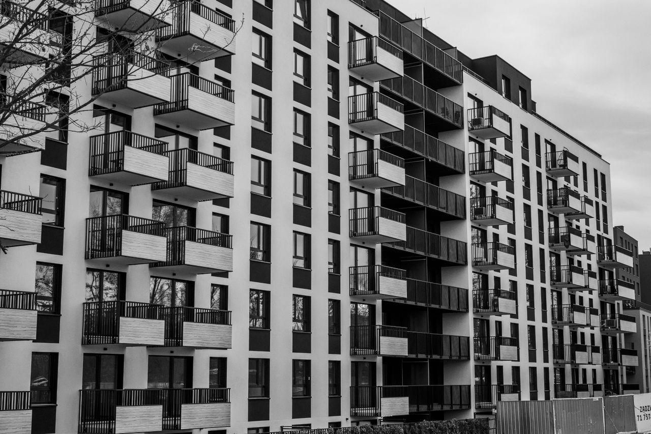 Black and white photo of a contemporary apartment building with multiple balconies.